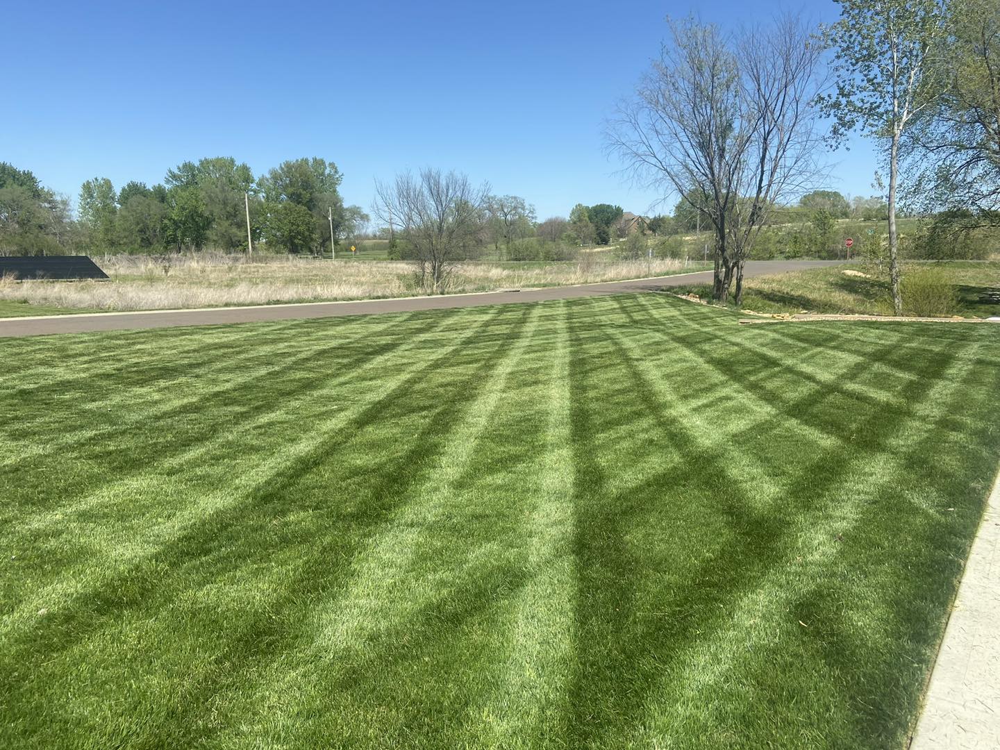 A front lawn mowed in clean stripes.